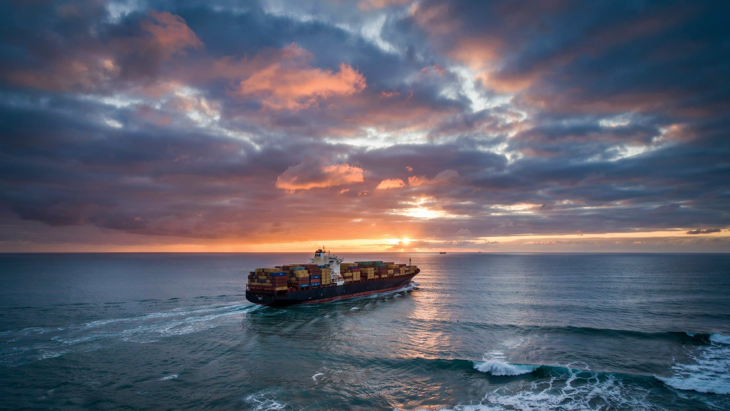 Large container ship navigating open ocean representing global shipping demand